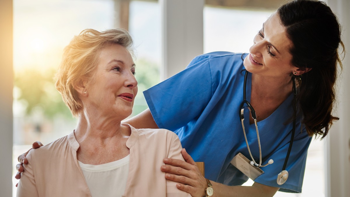 enfermeira sorrindo para idosa: áreas da enfermagem