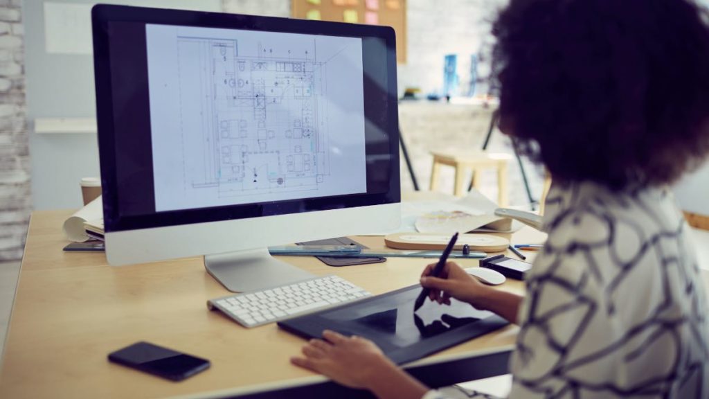 mulher desenhando no teclado do computador: o que faz um arquiteto
